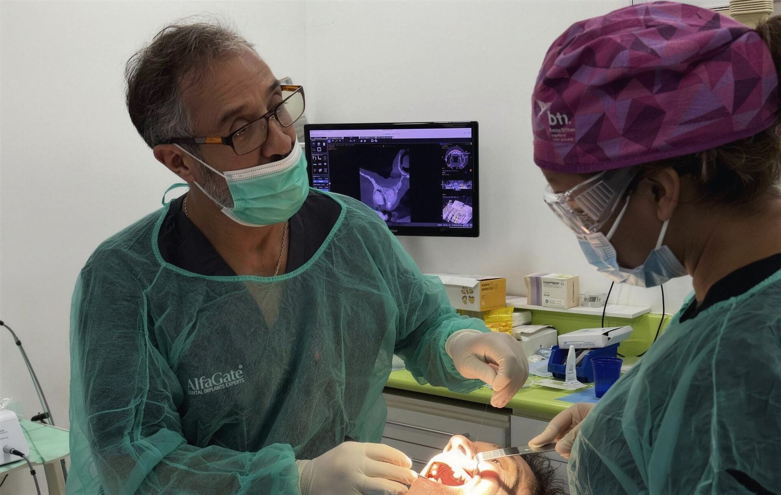 El Dr. Mariano Gallardo y su asistente atendiendo a un paciente en Dental TT, con el TAC en pantalla